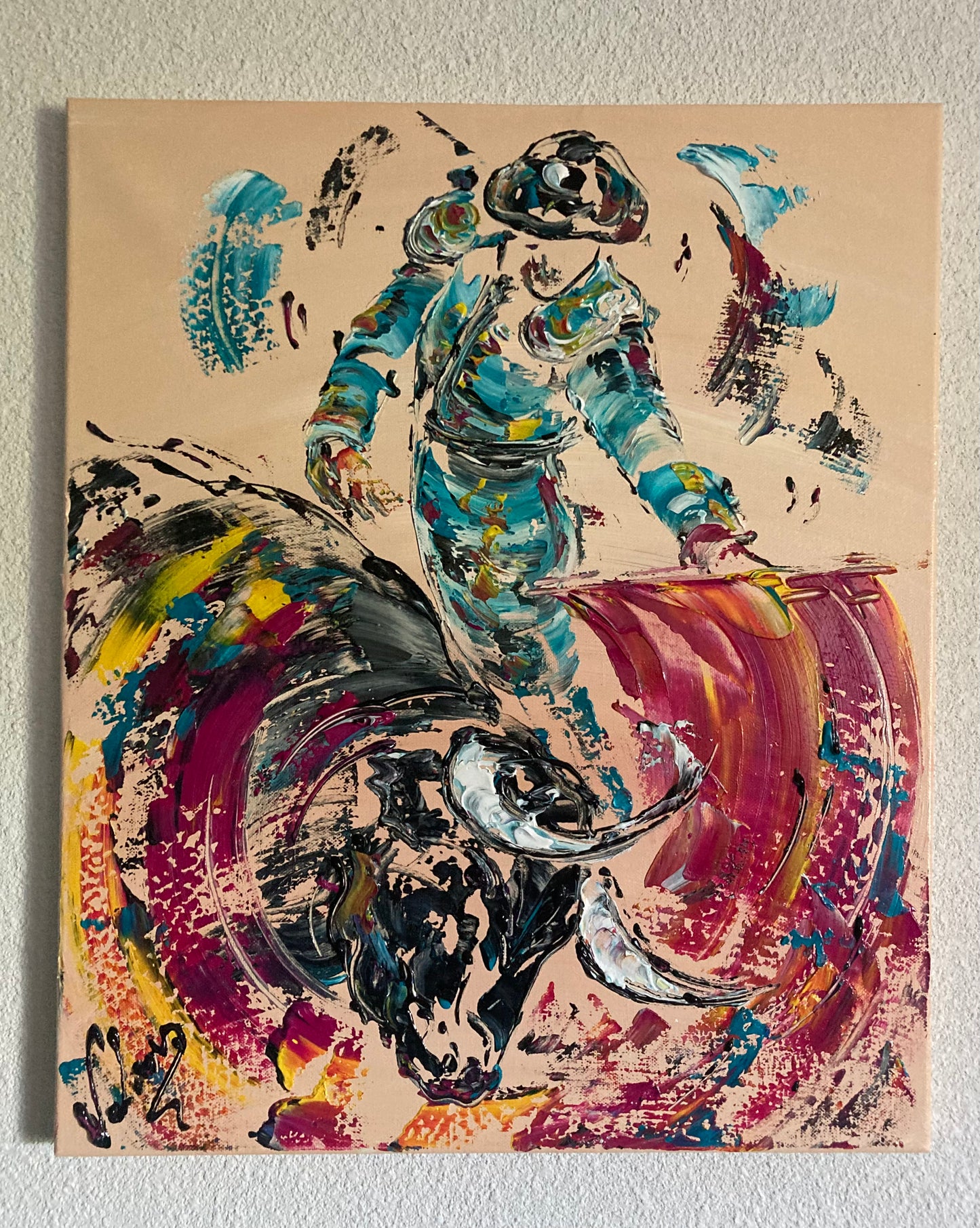 Tableau d’une corrida tauromachie avec un torero en costume turquoise et un taureau noir qui fonce sur la cape couleur fushia format 54x46 cl peinture sur toile fait à la spatule. Peintre Virginie Lunard