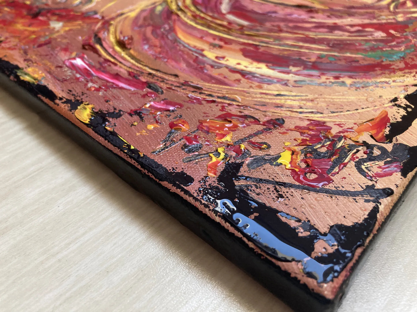 Zoom sur les reliefs de la peinture au couteau. Détail des textures rouges et marron évoquant le mouvement de la muleta et l'arène.