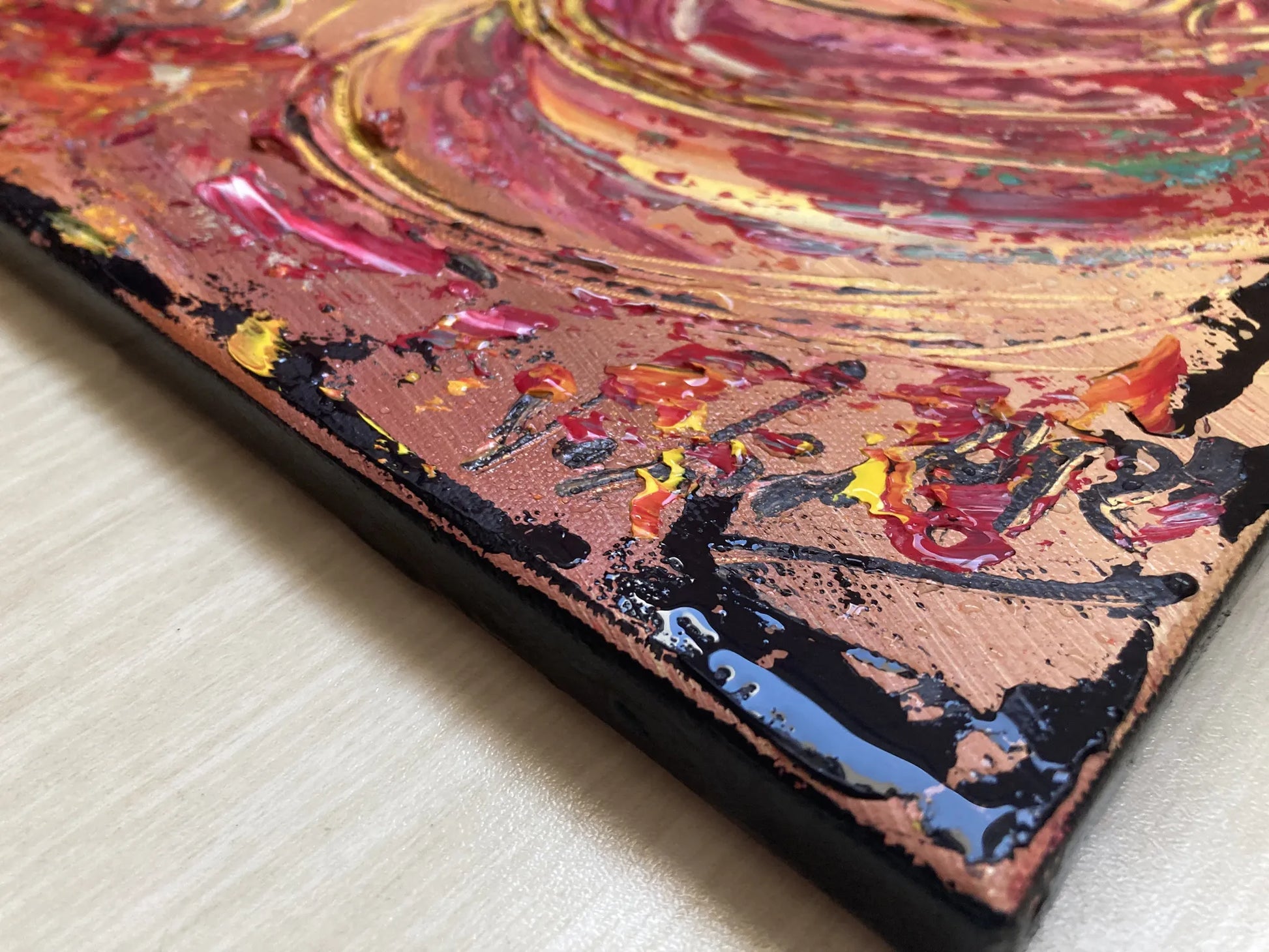 Zoom sur les reliefs de la peinture au couteau. Détail des textures rouges et marron évoquant le mouvement de la muleta et l'arène.